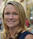 A person with straight blonde hair is smiling and looking slightly to the side. Description generated by AI